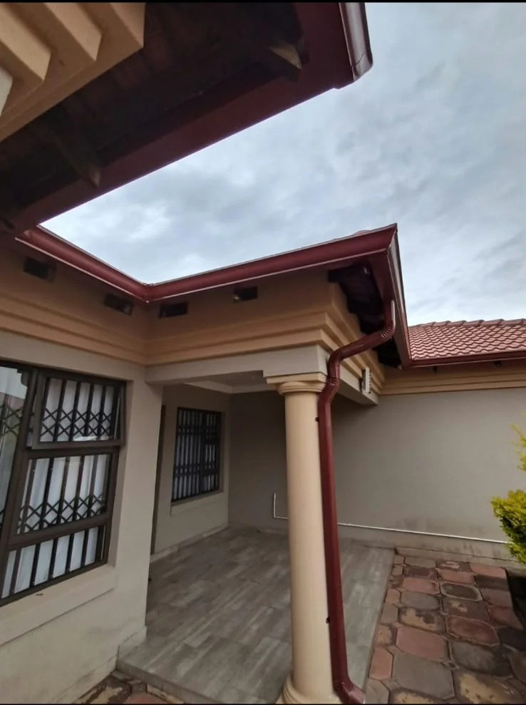Seamless red gutters and downpipe fitted to a residential property